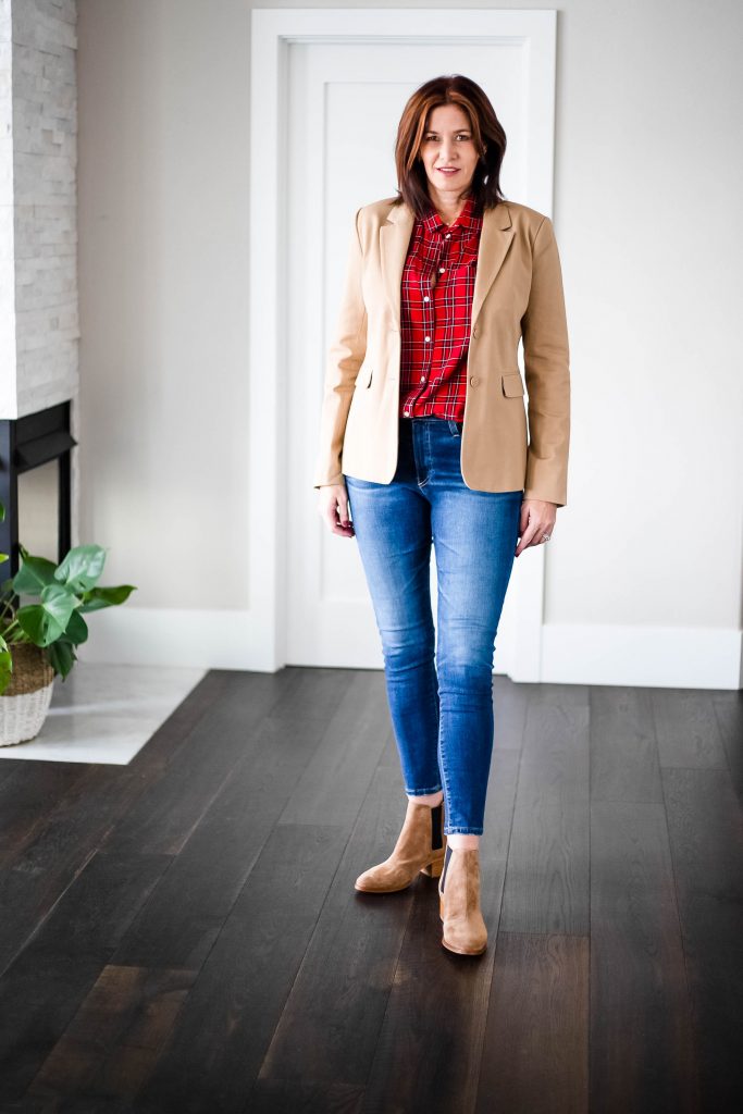 Midlife women wearing plaid top with tan blazer, ag jeans and booties