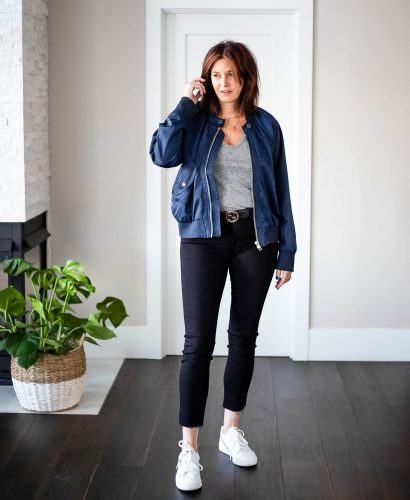 Over 40 women wearing True Blue bomber jacket with grey tee & black pants