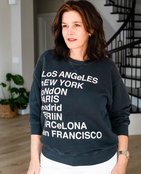 Over 50 women wearing graphic sweatshirt with white jeans