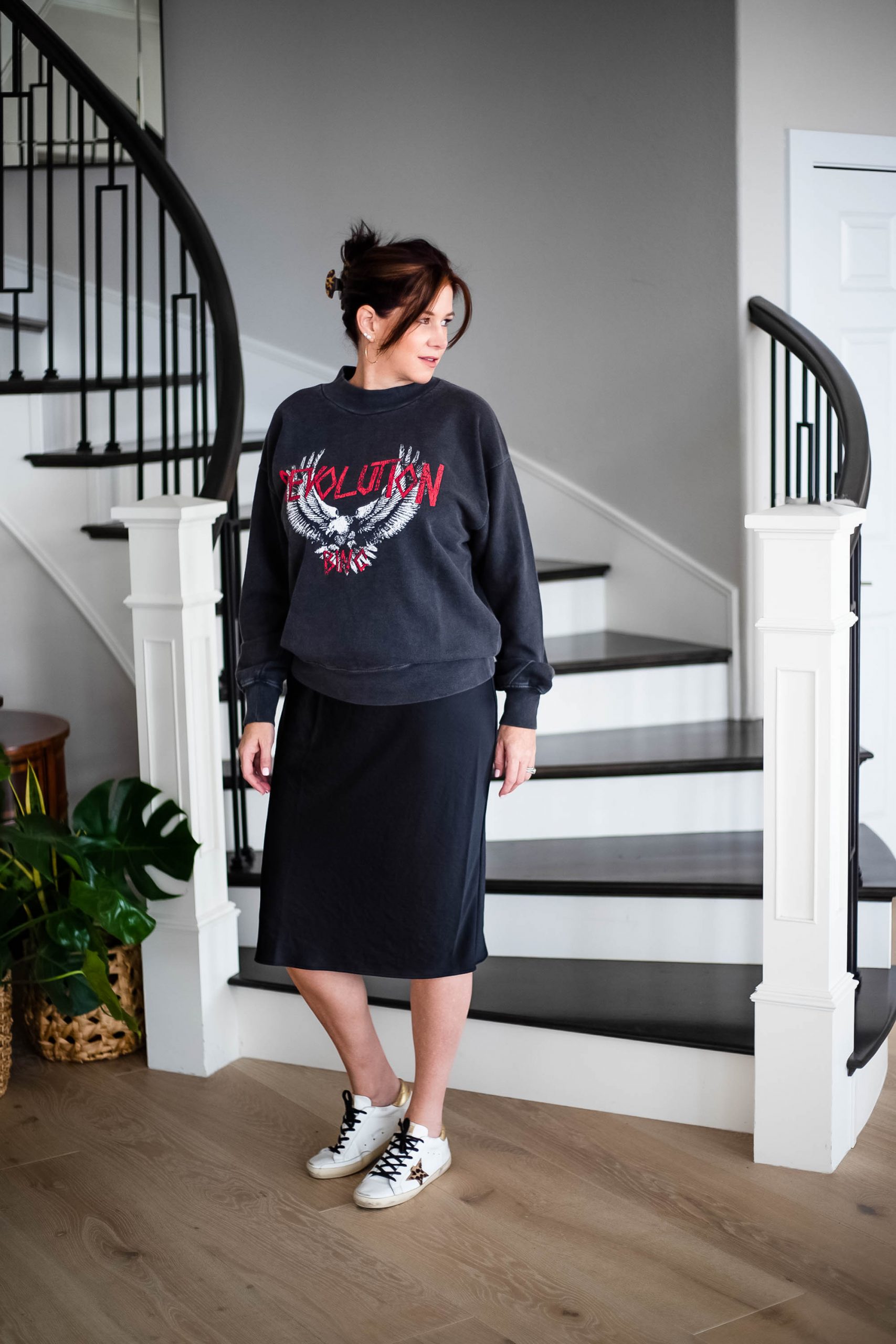 Over 50 women wearing a graphic sweatshirt over a slip dress