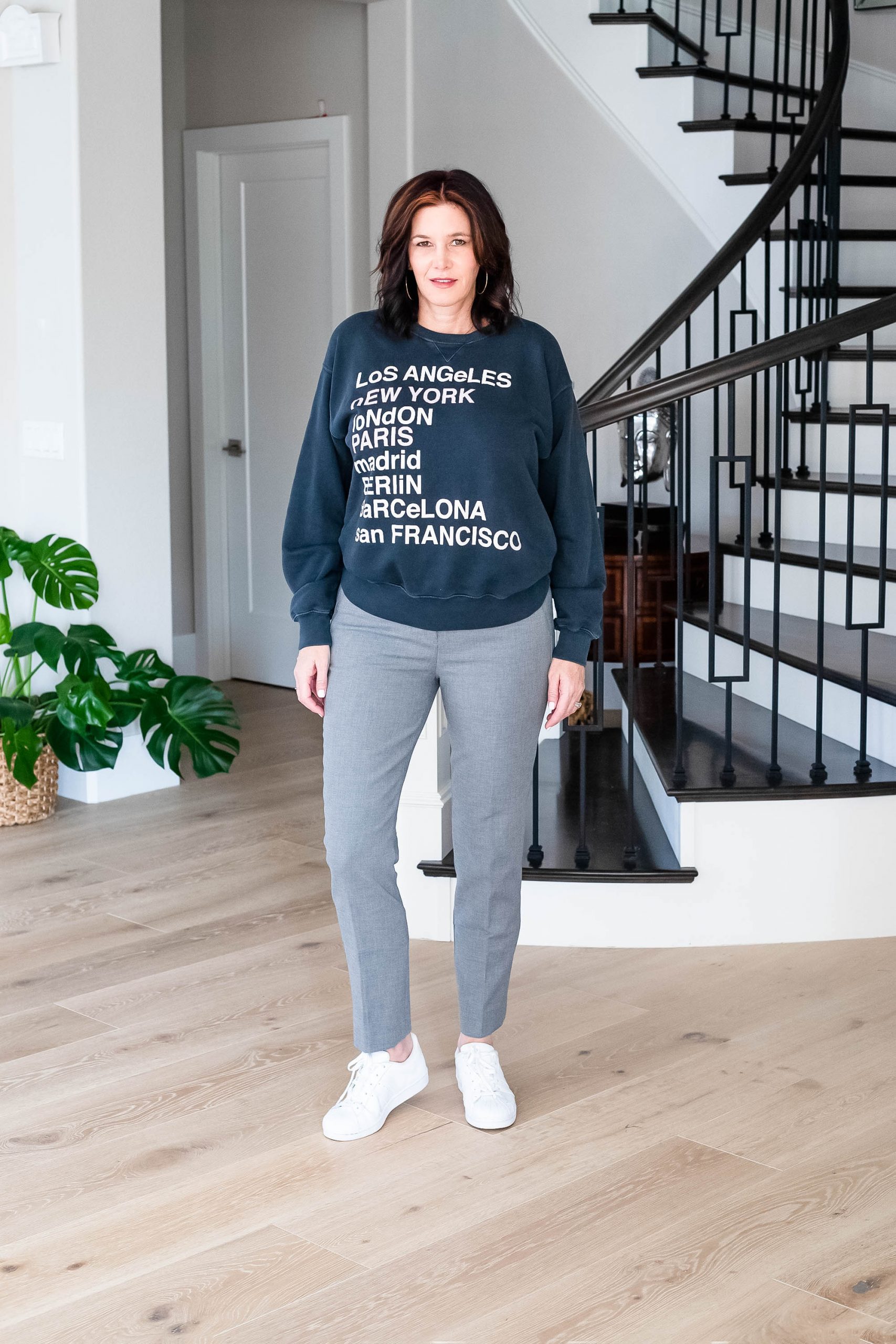 Over 50 women wearing grey suit with graphic sweatshirt and sneakers