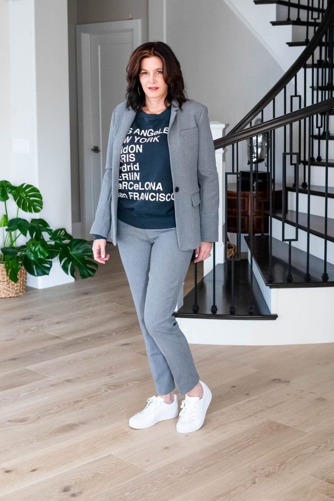 Over 50 women wearing grey suit with graphic sweatshirt and sneakers