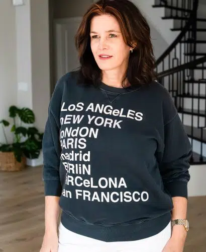 Over 50 women wearing graphic sweatshirt with white jeans