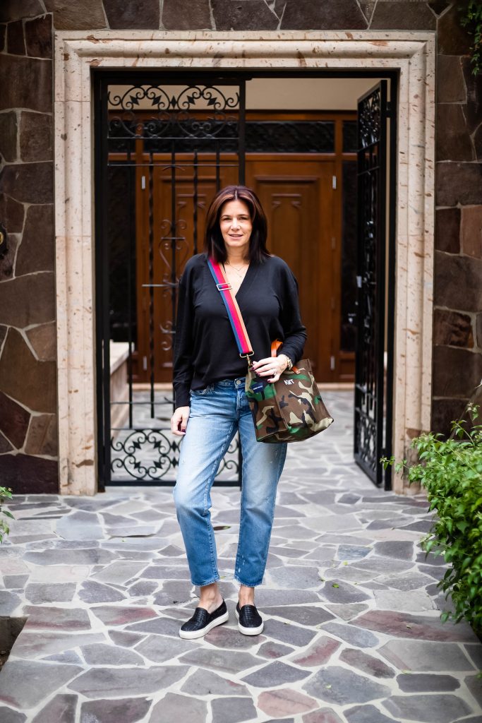 Midlife women in moussy vintgage jeans, rag & bone top, Parker Thatch bag and M.Gemi Sneakers