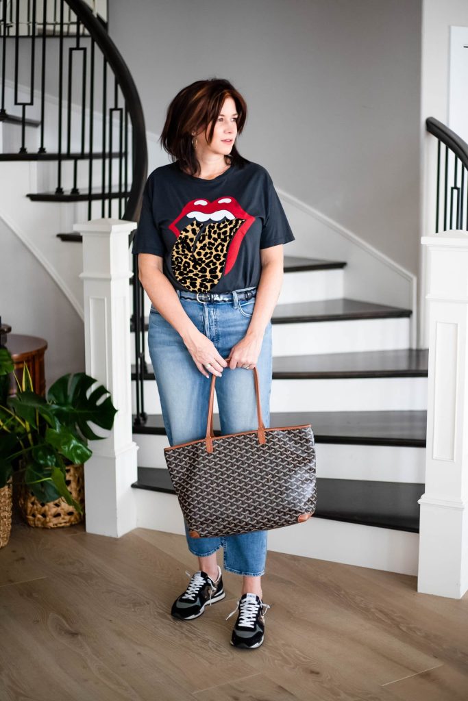 Over 50 women wearing Free People top, straight leg denim and Goyard tote