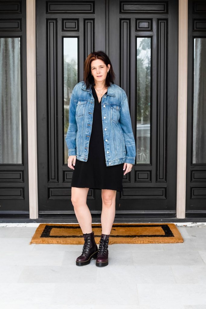 Midlife women wearing Dr. Marten's, black dress and Madewell oversized denim jacket.