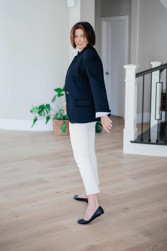 Over 50 women wearing ivory jeans with black tank top and blazer