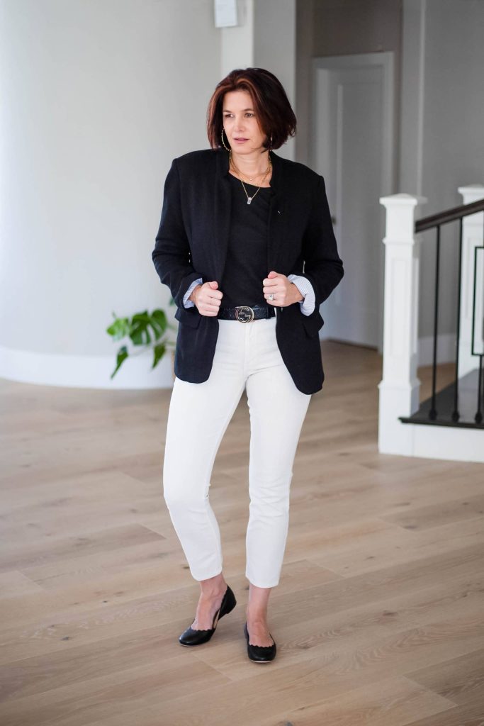 Over 50 women wearing ivory jeans with black tank top and blazer