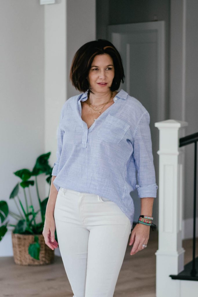 Midlife women wearing ivory jeans, striped popover top and leopard sandals.