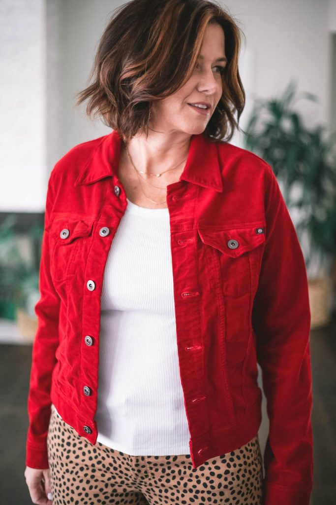 Over 50 women wearing AG red corduroy jacket and AMO white tank