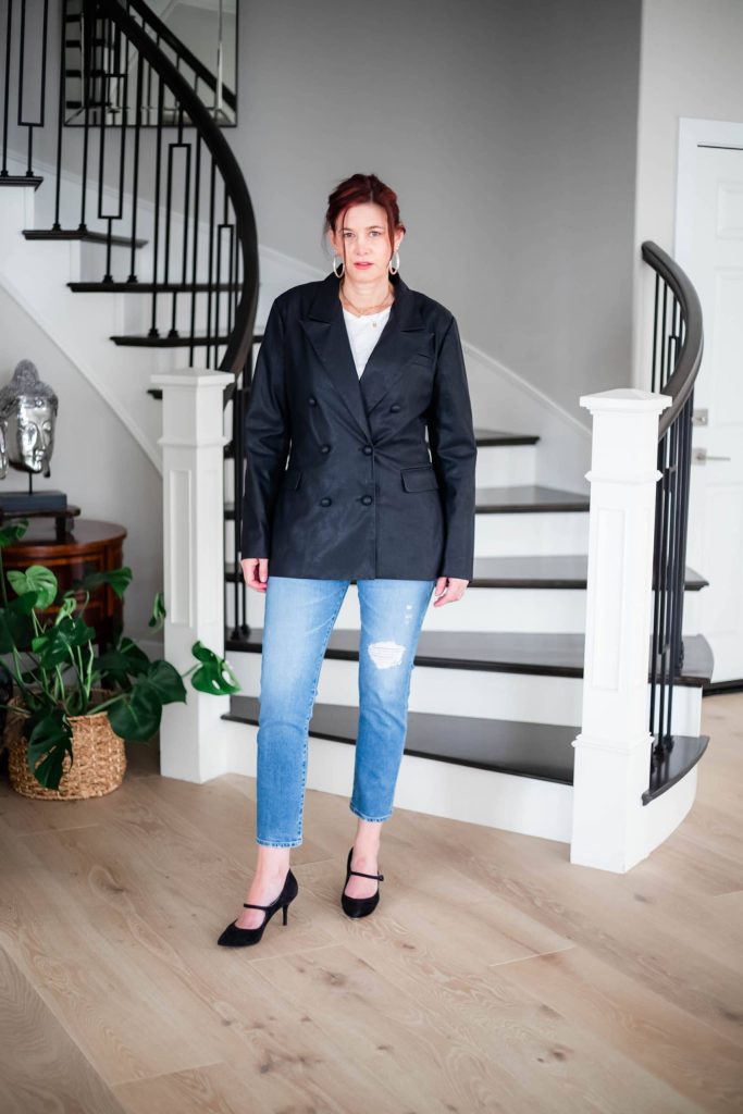 Women wearing faux leather blazer, jeans and heels.