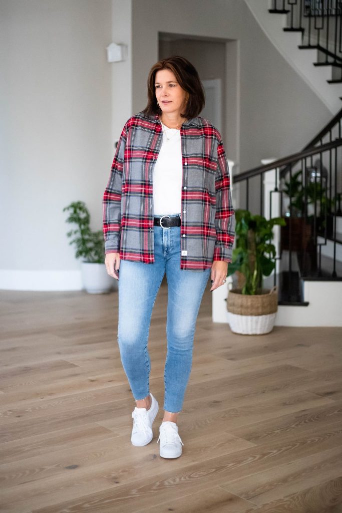 Midlife women wearing flannel shirt, white tee, jeans and sneakers