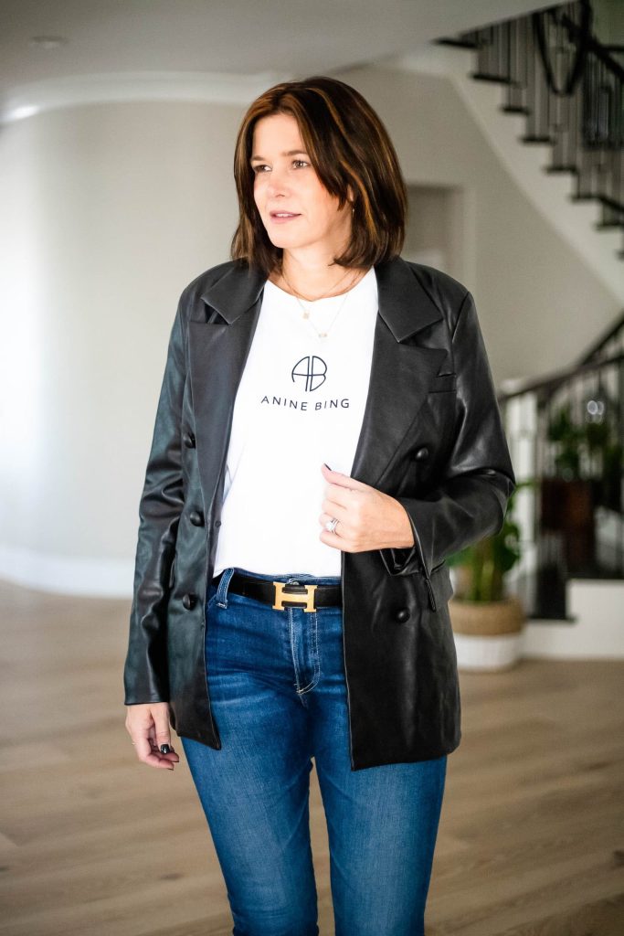 Midlife women wearing faux leather blazer, Tee and jeans