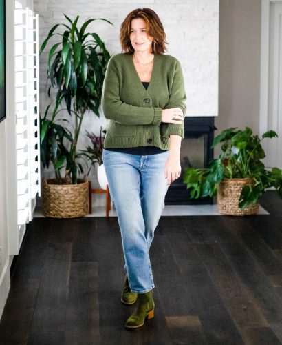 Over 50 women wearing cropped cardigan, jeans and green booties