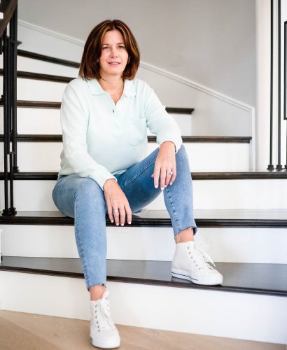 Women wearing collared cashmere sweater with jeans and sneakers