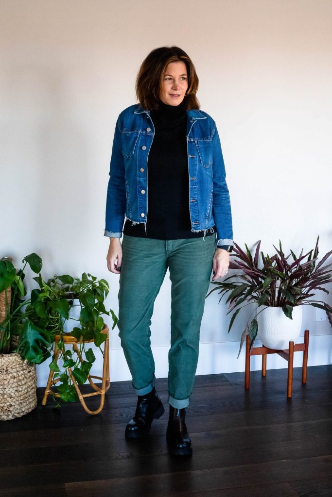 Women wearing green corduroy pants, black turtleneck, jean jacket and boots.