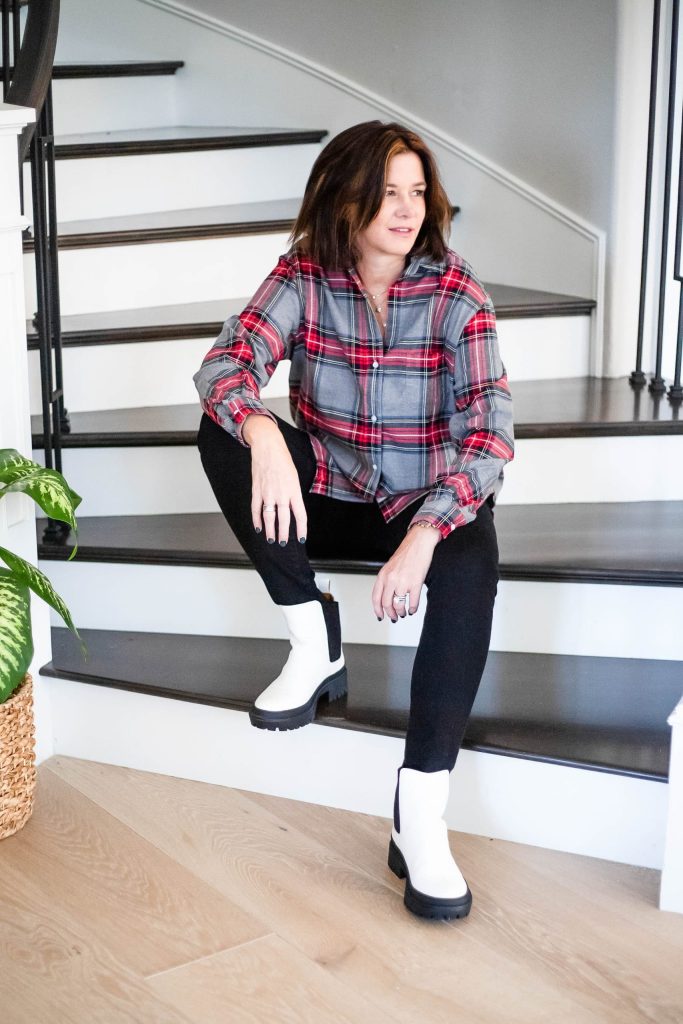 Women wearing white lug sole boots, plaid flannel and black jeans.