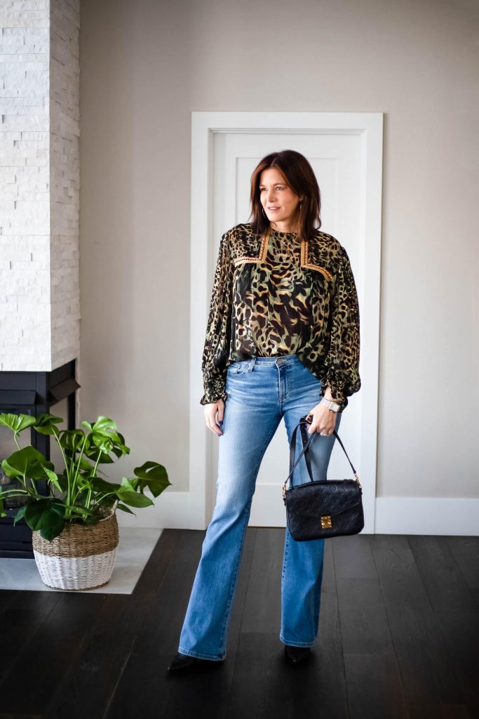 Midlife women wearing bootcut jeans and floral top.