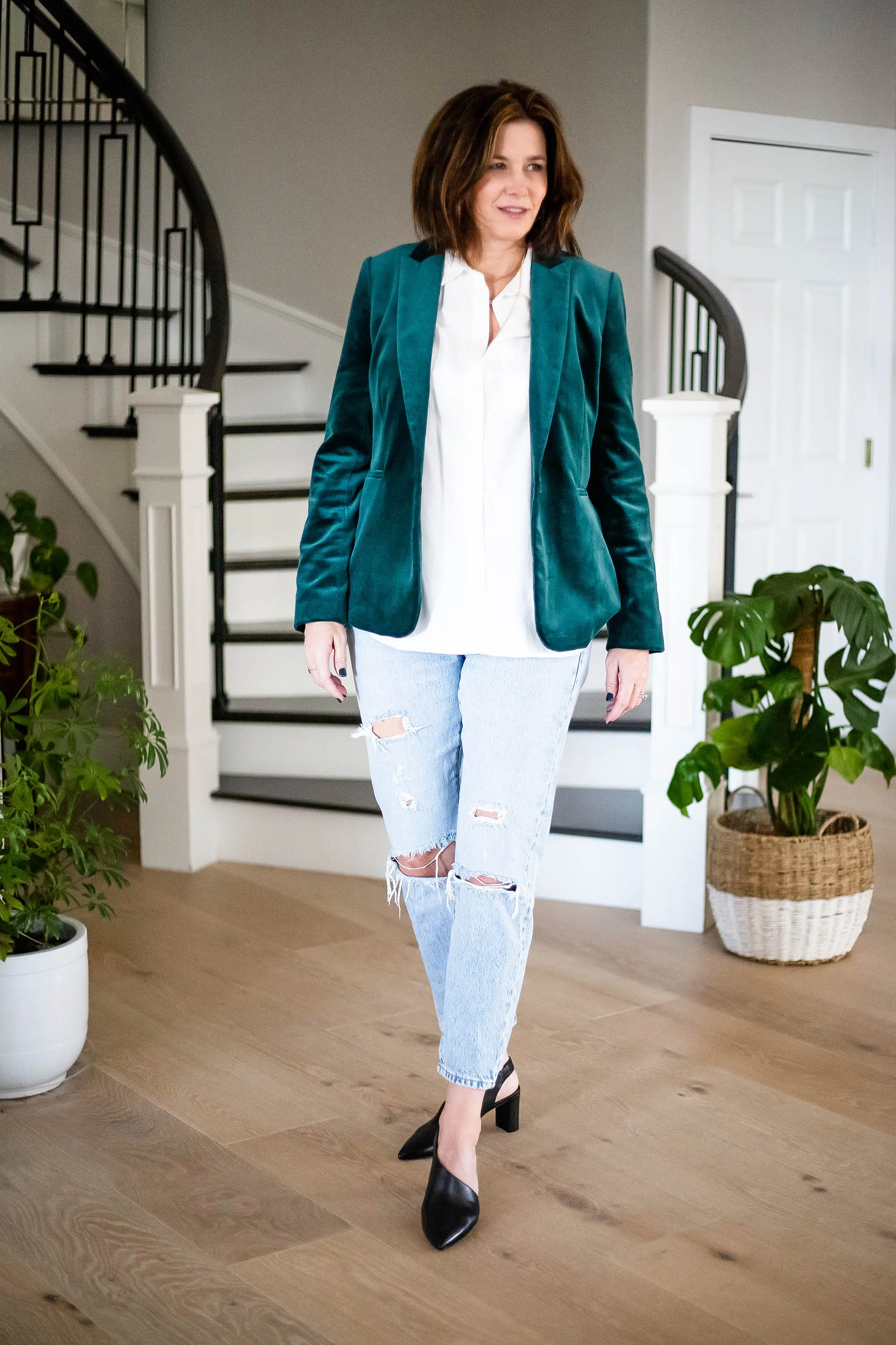 Women wearing velvet blazer, white shirt, ripped jeans and heels.
