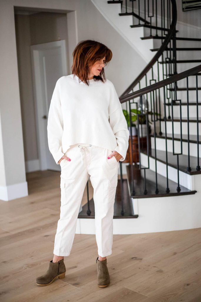 Midlife Women wearing clog boots, cream joggers and sweater.
