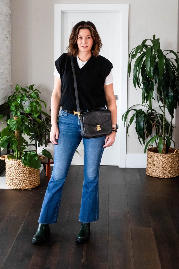 Midlife women wearing sweater vest, white tee, flare jeans and loafers