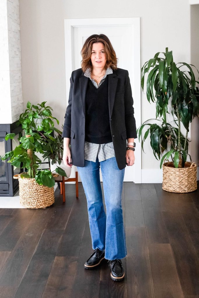 Midlife women wearing sweater vest, button down shirt, blazer, jeans and loafers