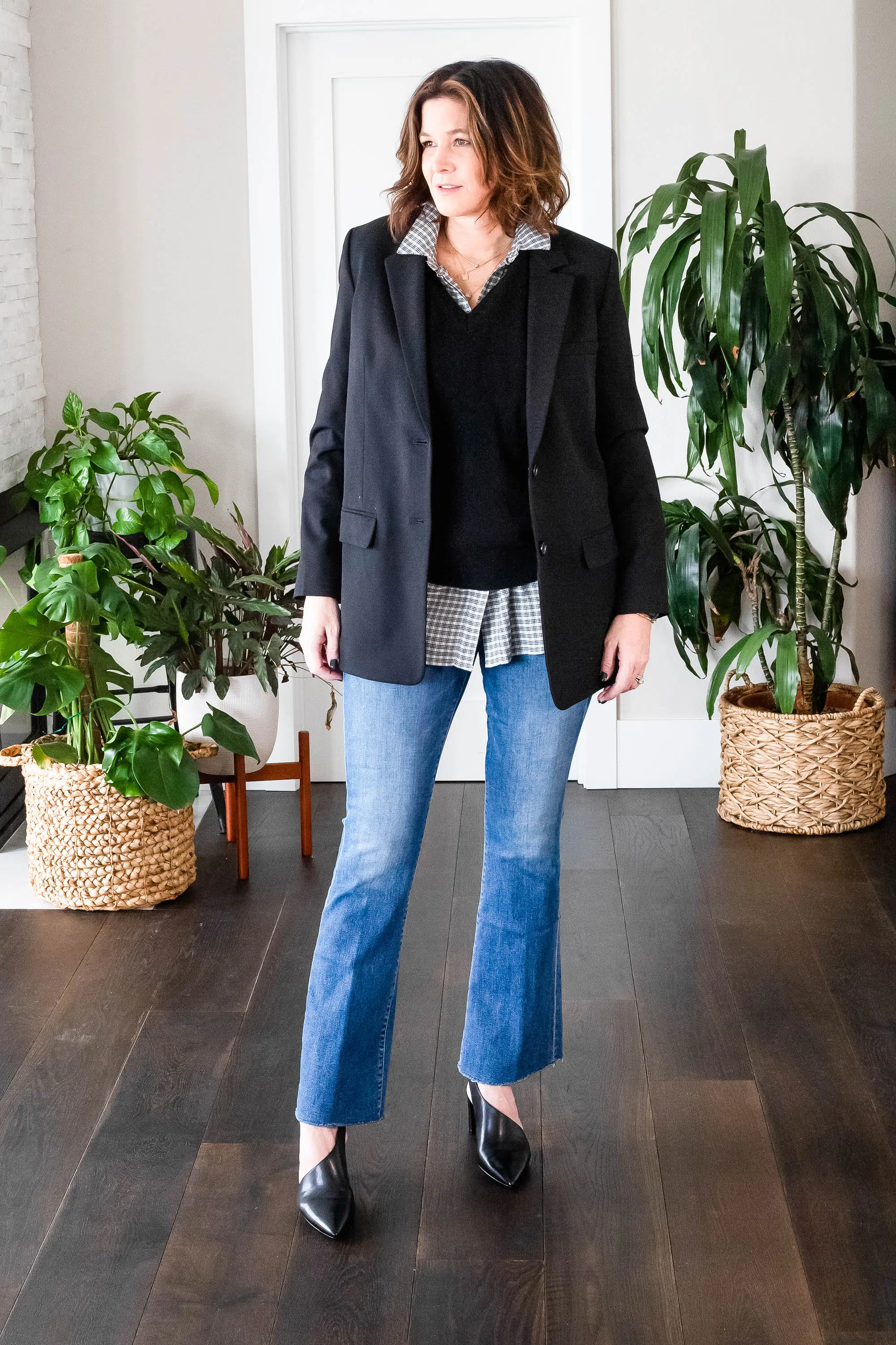 Midlife women wearing sweater vest, button down shirt, blazer, jeans and heels.