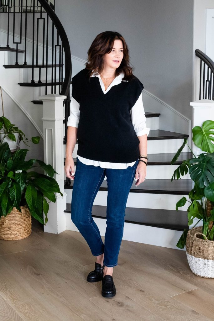 Midlife women wearing sweater vest, button down shirt, straight leg jeans and loafers