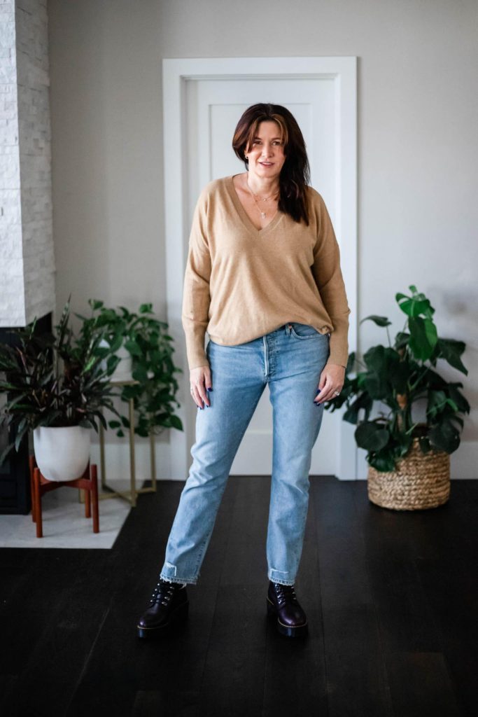 Midlife women wearing Dr. Martens, tan sweater, straight leg jeans.