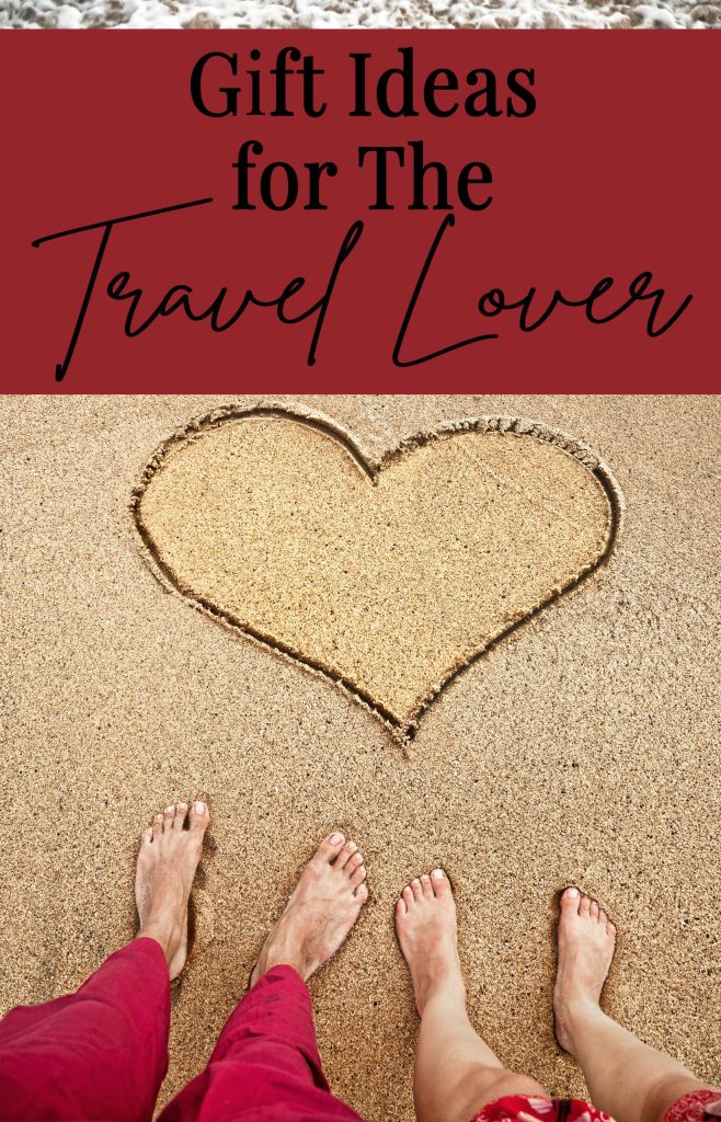Travel Lover Legs of young couple standing on the beach near heart on the sand with ocean near by
